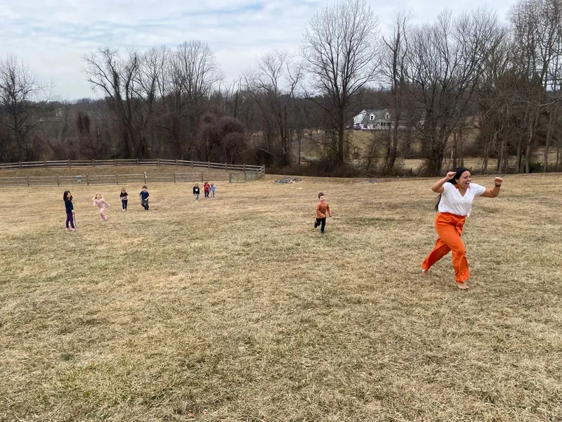A teacher racing children across the big field